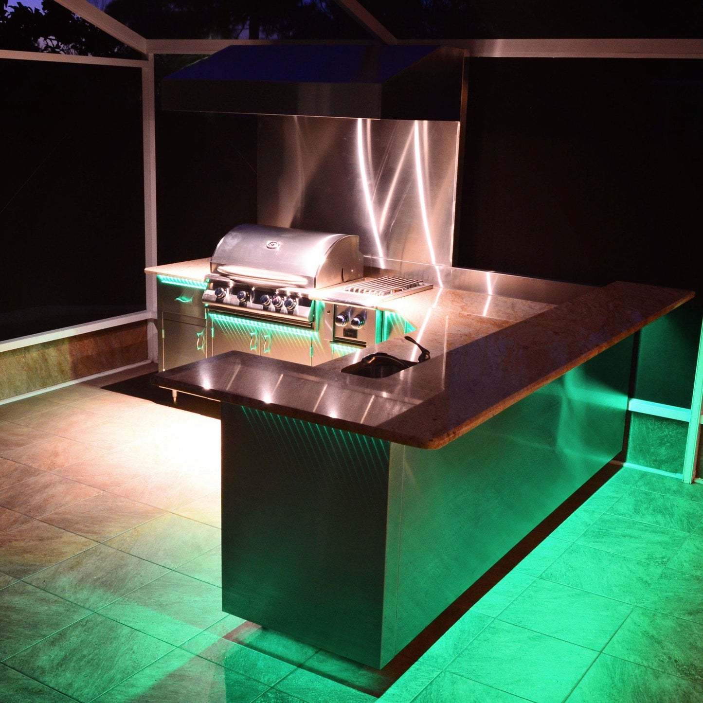 outdoor home bar and grill area illuminated by green light from led strip light installed under bar counter