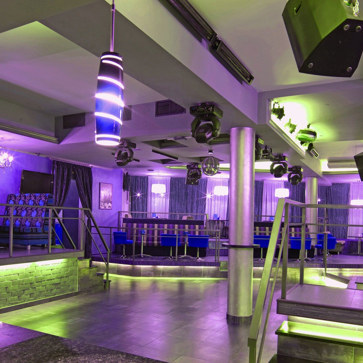 purple and green hued banquet hall with blue accent furniture, 6 lighting projectors on ceiling, and a disco ball