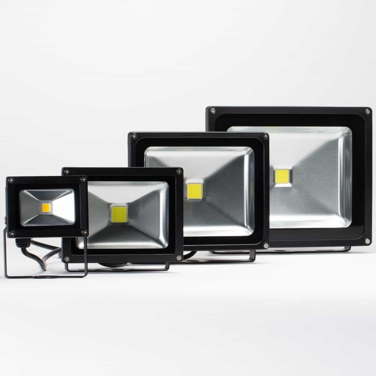 four led flood lights with black housing and clear front lens arranged left to right in small to large order