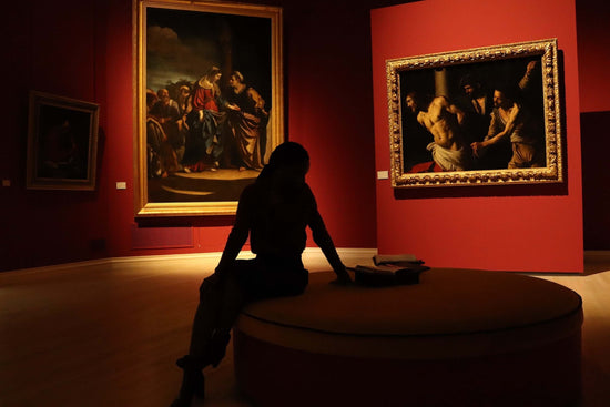 Silhouette Of A Person Sitting On Round Chair In Front of Museum Artwork