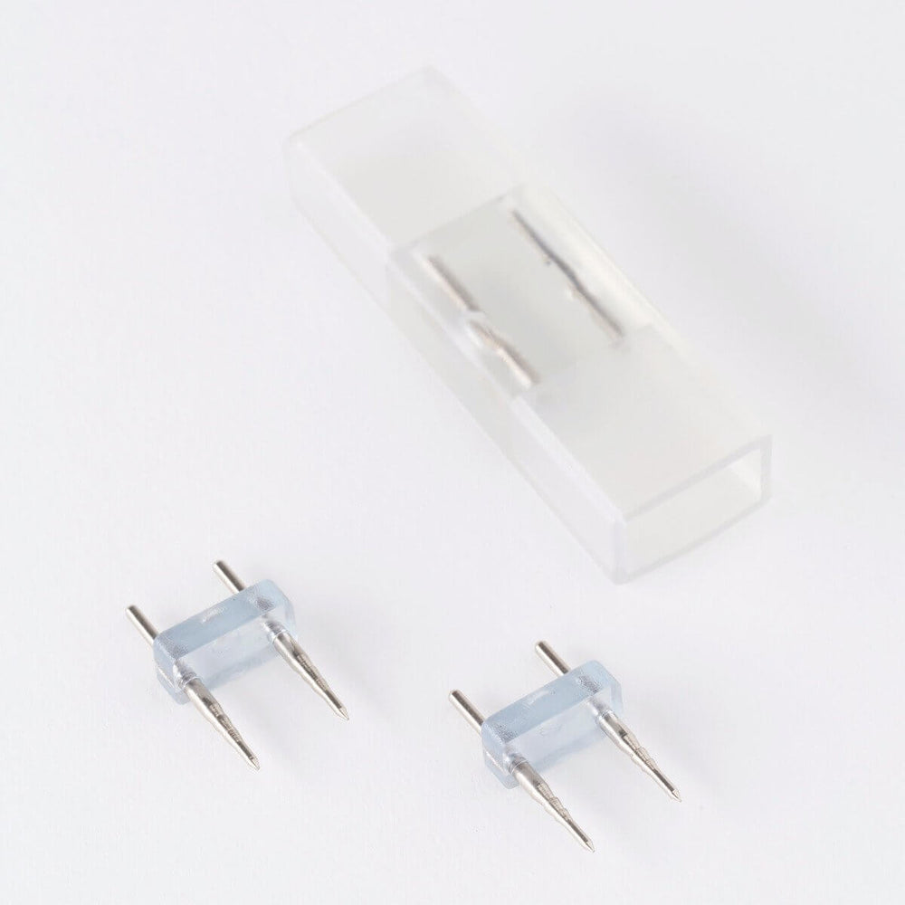 
                      
                        clear silicone led strip light splice connector with visible silver internal wiring and two led pins
                      
                    