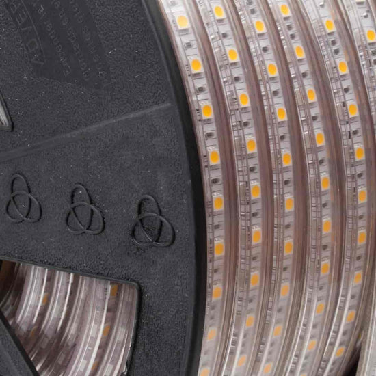 Load image into Gallery viewer, close up shot of 120V led strip lights with visible yellow led chips on black reel with lumilum knot logo
