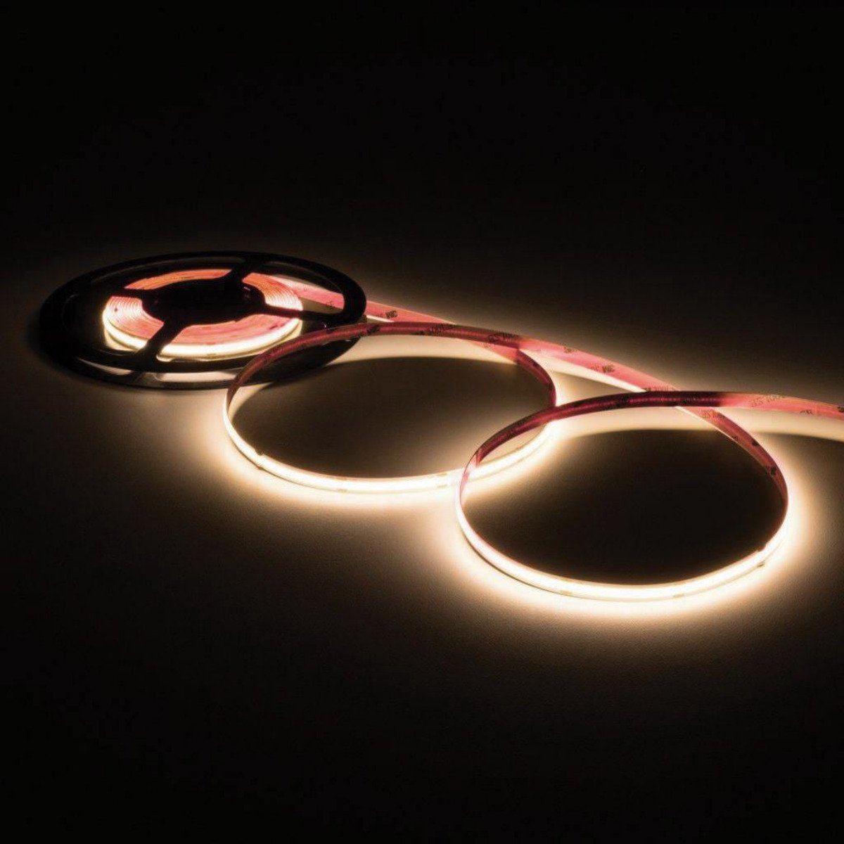 Load image into Gallery viewer, illuminated warm white led strip light loosely coiled three times off of a black reel
