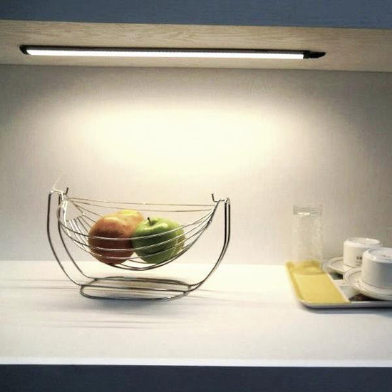 under cabinet kitchen area with fruit basket and dishes illuminated by linear led light bars