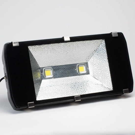 rectangular outdoor led flood light in black housing with clear front lens and visible led chips in center